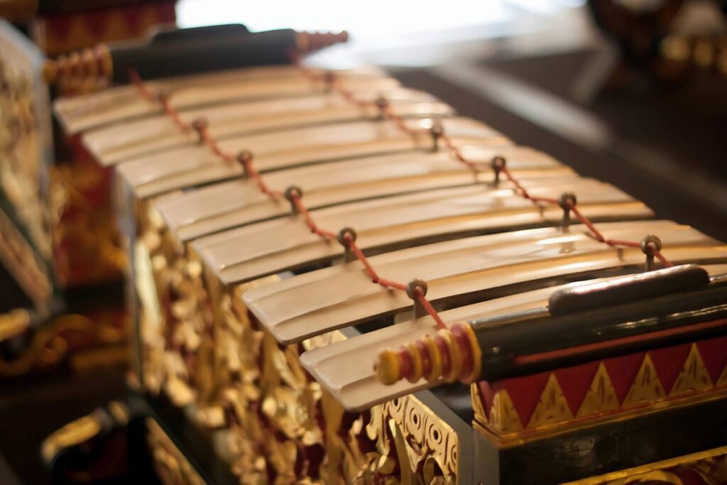 A close-up, shallow-focus shot of a traditional Balinese metal percussion instrument called a Gamelan.