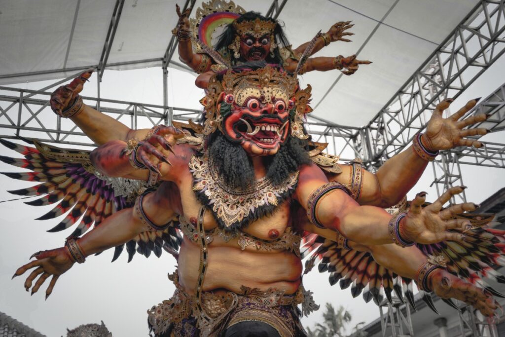 Large Ogoh-Ogoh demon statue with many arms displayed during Bali’s Nyepi festival parade.