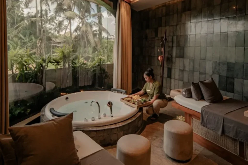 Luxury spa room with a jacuzzi and therapist preparing treatments, showing a relaxing wellness experience in Bali.