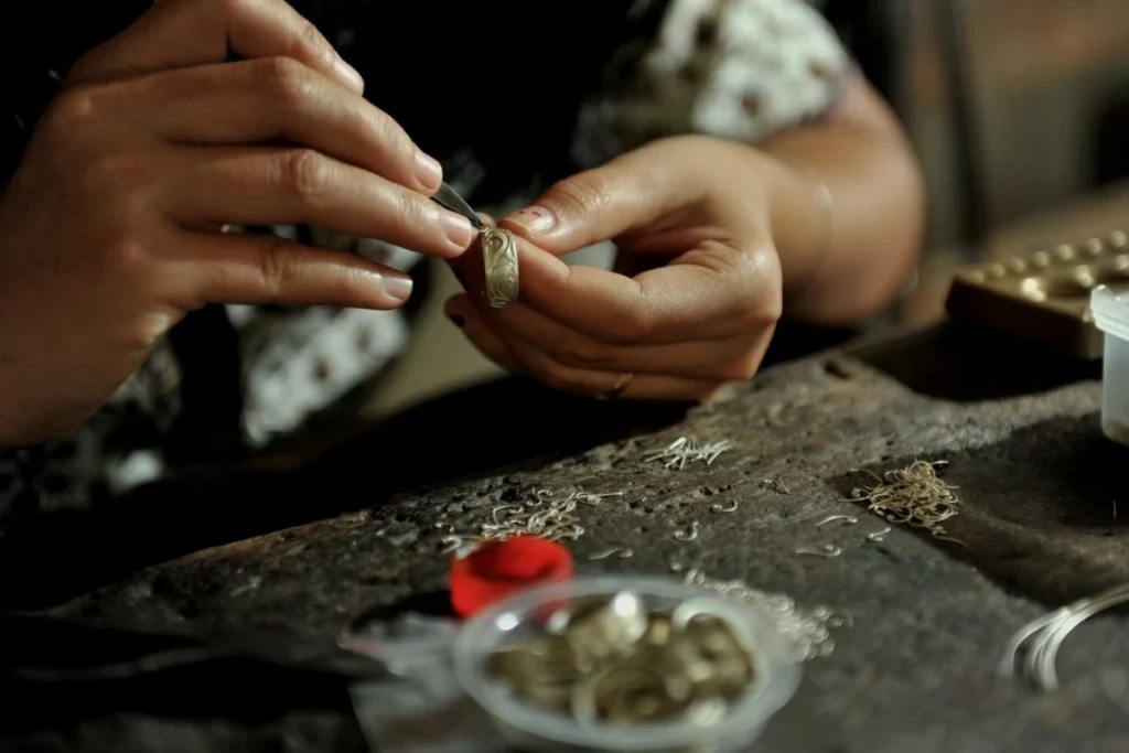 A craftsperson carefully shapes a silver piece by hand at a traditional workshop in Celuk, Bali.